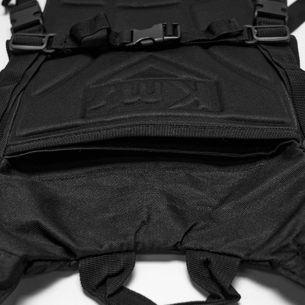 Tactical backpack pocket detail featuring padded black fabric, zippered compartment, webbing loops, and embossed branding