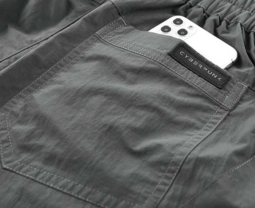 Close-up top view of tactical shorts back zippered pocket showing capacity for smartphone and storage functionality