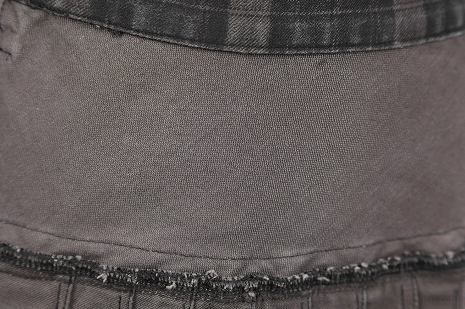 Close-up texture shot of dark grey-brown plaid fabric weave and cotton-spandex composition