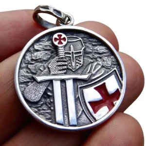 Close-up detail of Knights Templar pendant held in hand, showing antique silver finish and red enamel cross details