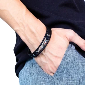 Men's treble clef leather bracelet worn on male arm model showing side perspective view with casual daily outfit background gothic alternative fashion styling