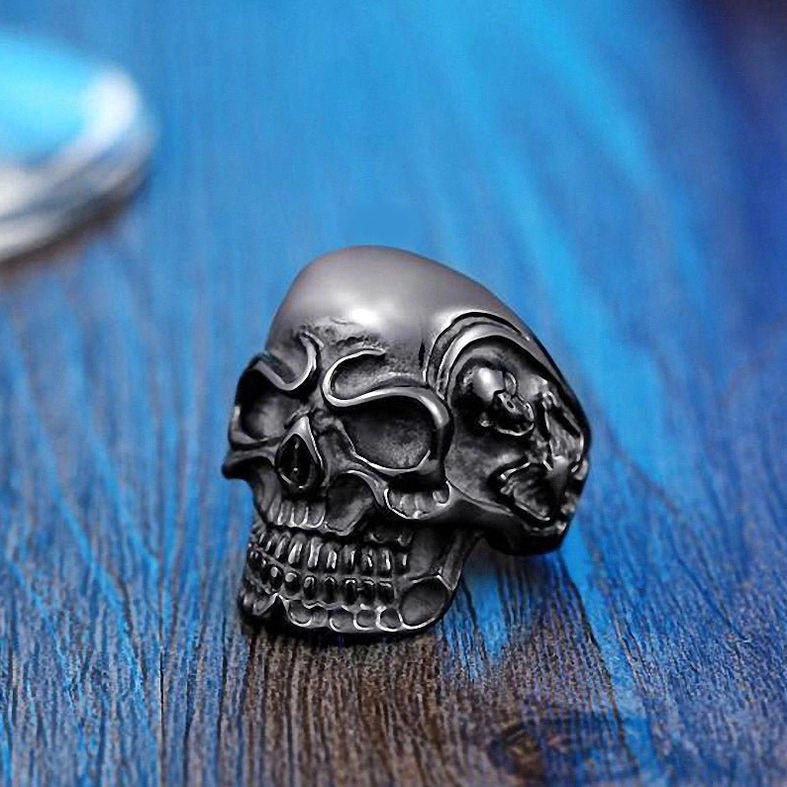Black triple skull gothic ring with detailed embossed skull texture - side profile close-up