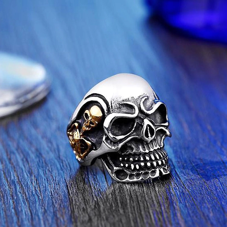 Triple skull gothic ring side view showing three-dimensional skull relief