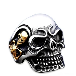 Dual-tone triple skull gothic ring with silver body and gold inlay detail - front overhead view with vintage finish