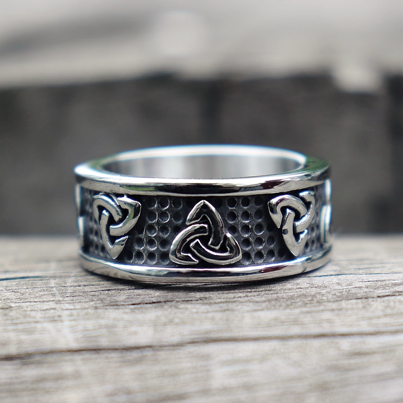 Triquetra band ring flat front view on wooden surface showing full circular Celtic knot engravings