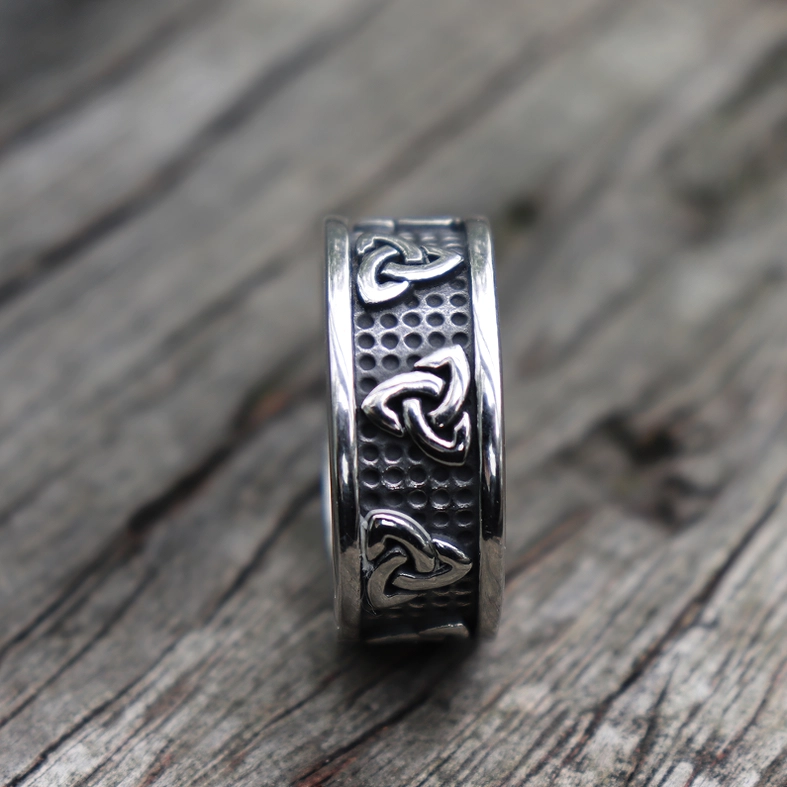 Triquetra stainless steel ring end-on front view showing stacked Celtic knot designs on textured band