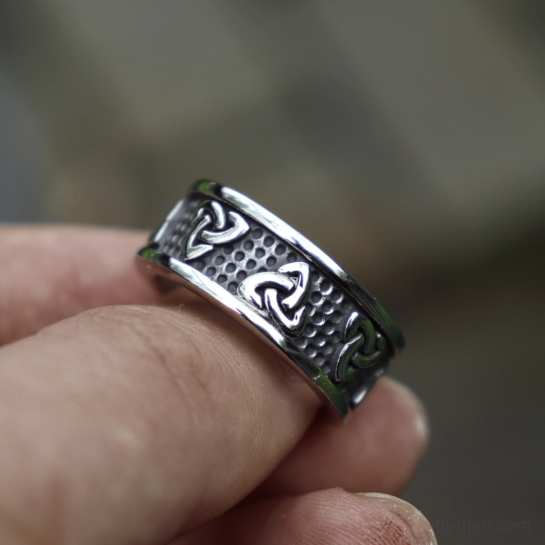 Stainless steel triquetra ring side close-up view on finger showing texture and engravings detail