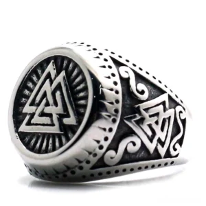 Valknut signet ring three-quarter view showing engraved Norse knot symbol and ornate scrollwork band in polished stainless steel
