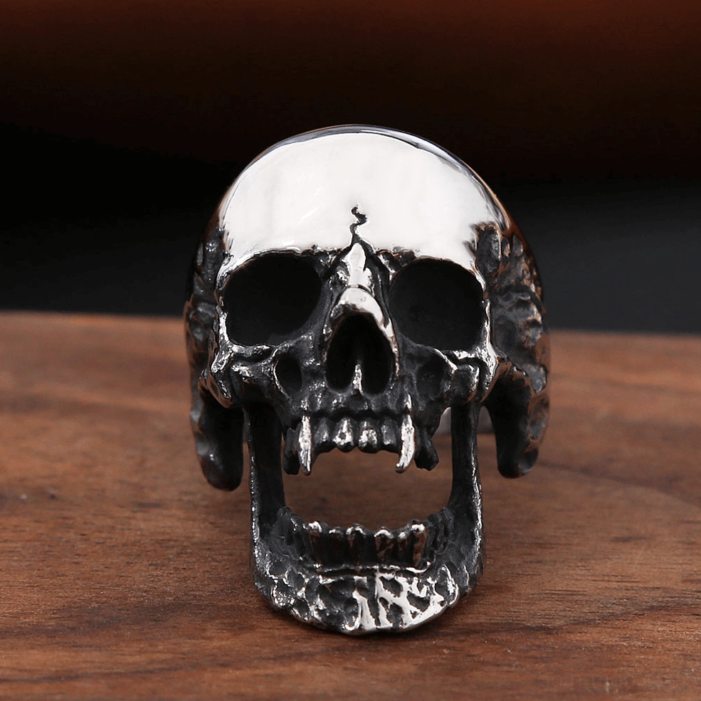 Vampire skull gothic ring direct front close-up showing intricate skull details, textured jaw base, and refined gothic craftsmanship on wooden table