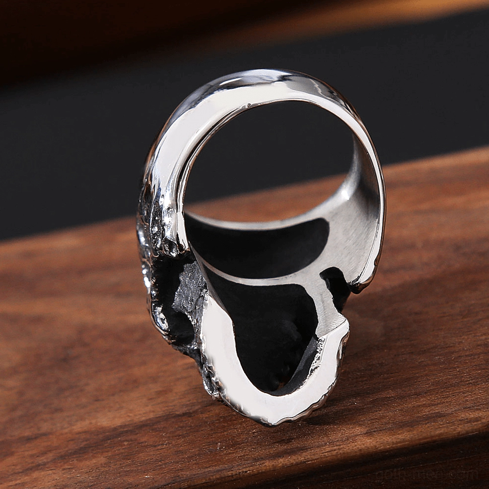 Vampire skull ring rear and bottom view displaying smooth polished metal band interior and hollow ring construction on wooden background