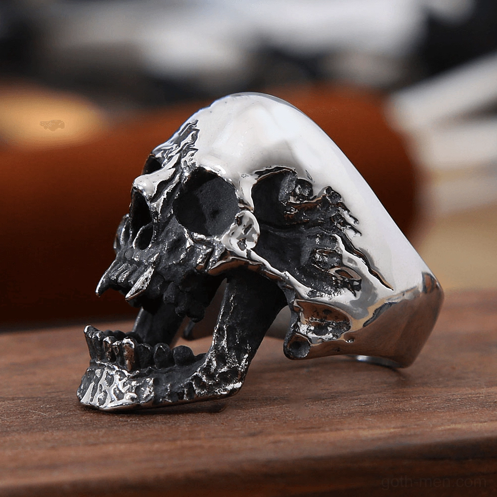 Vampire skull gothic ring side profile view displaying polished skull crown and textured lower jaw detail on wooden table background