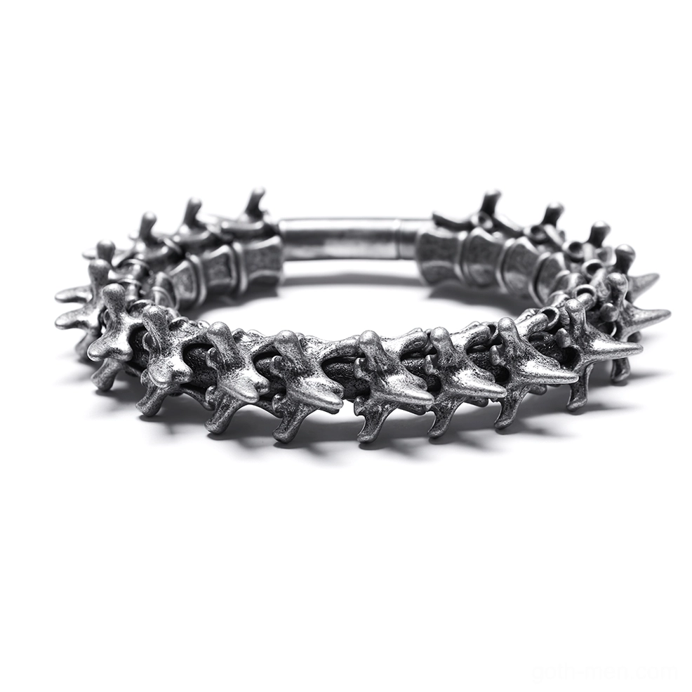 Vertebra spine metal arm cuff flat lay with full segmented spike structure and aged silver patina
