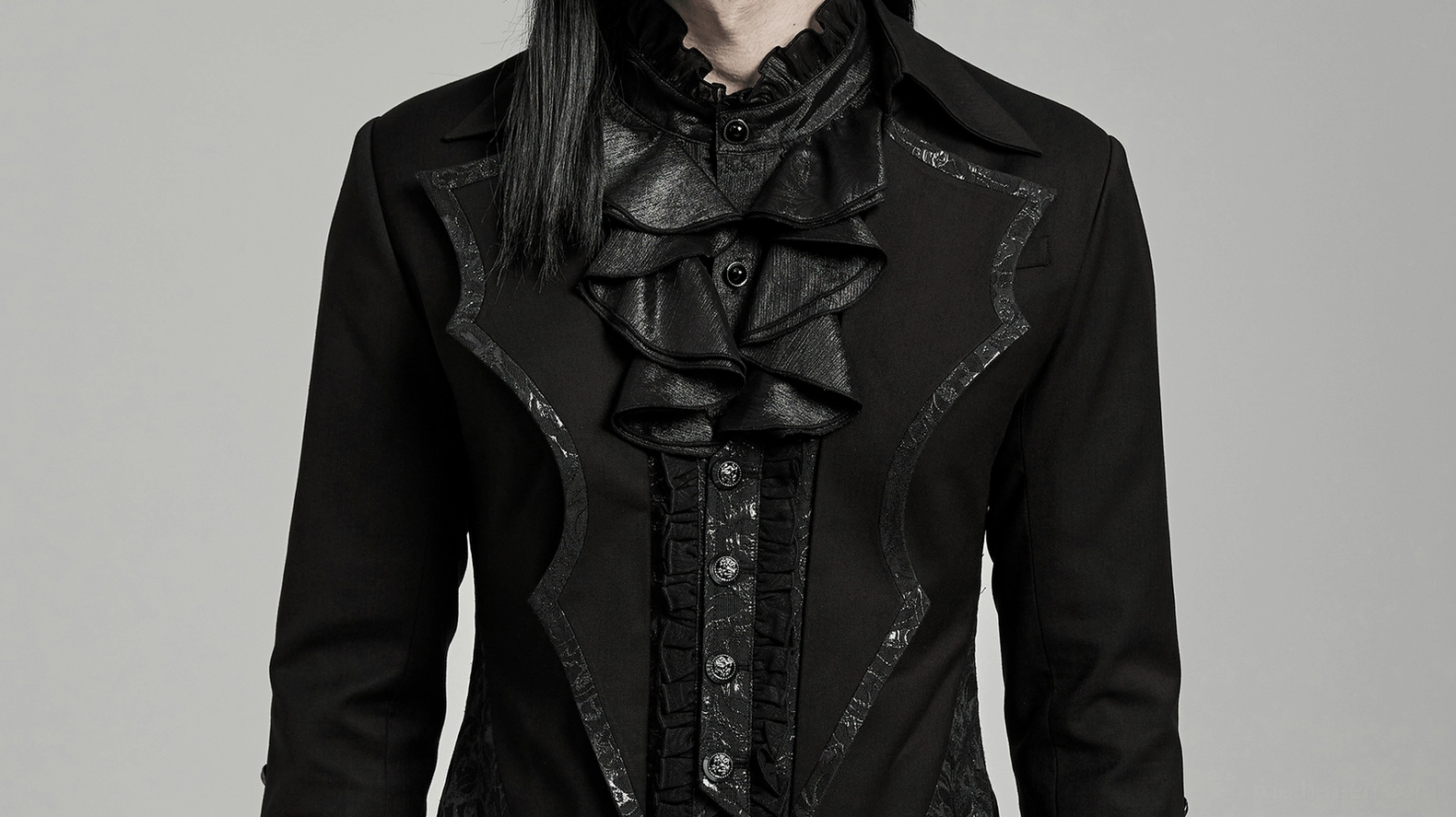 Close-up detail of Victorian gothic tailcoat ruffled neck trim and buttoned front placket on model