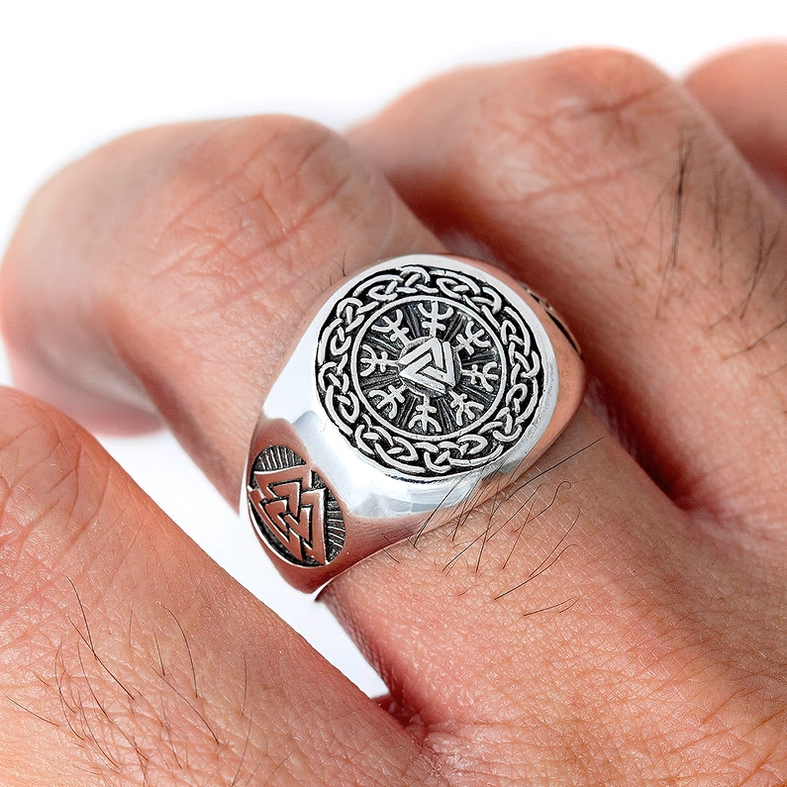 Viking Valknut signet ring worn on male finger - close-up showing black engraved patterns and copper-toned Valknut accent detail on stainless steel band