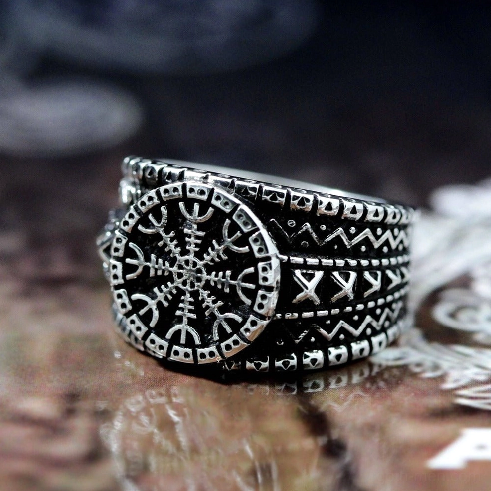 Viking protection ring on dark wooden background - side flat view of blackened Aegishjalmur engraving