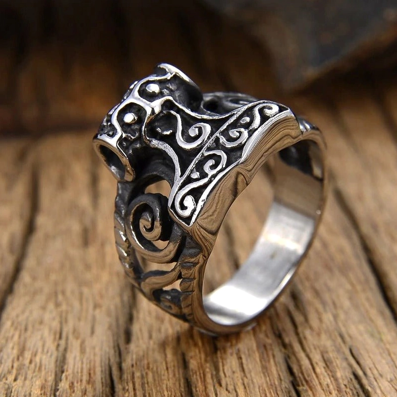 Thor's Hammer Viking gothic ring side view on retro wooden table with smooth polished inner band and detailed scroll engravings visible