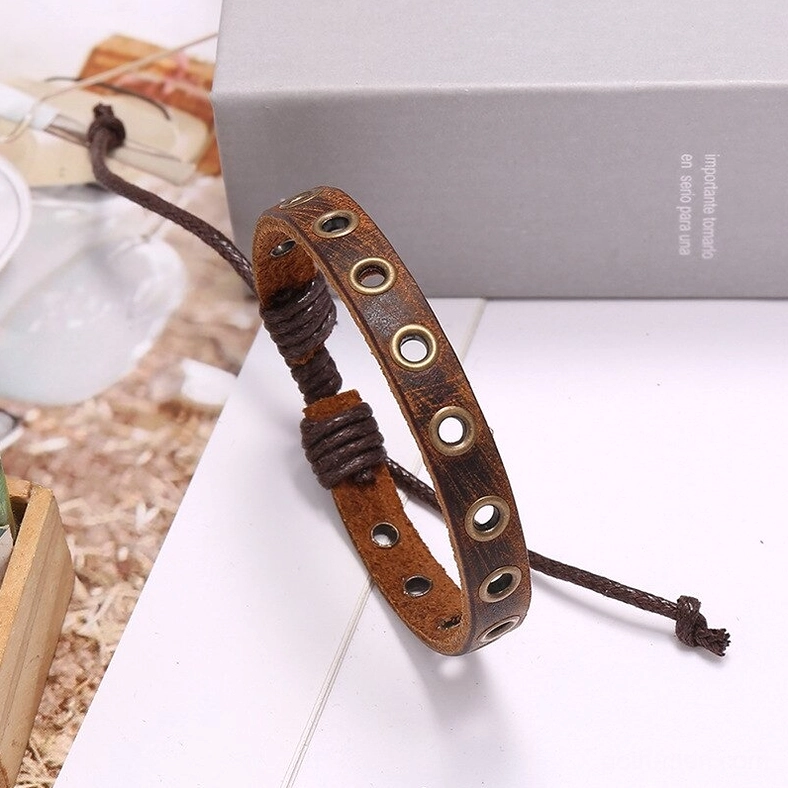 Angled view of brown leather gothic bracelet with braided pull-tie fastener and vintage styling