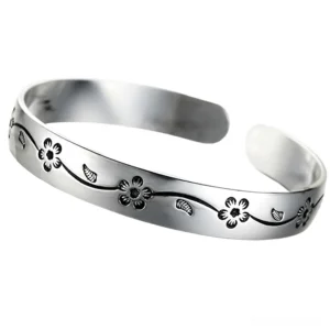 Adjustable open cuff gothic silver bangle with polished finish and etched blossom patterns, front flat lay display