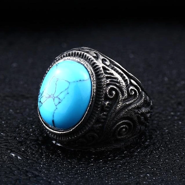 Vintage finish gothic turquoise ring, embossed motifs, oblique front view leather background