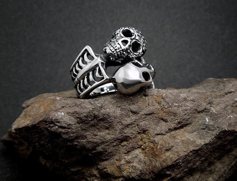 Dual skull gothic ring dark rock background polished and engraved finish