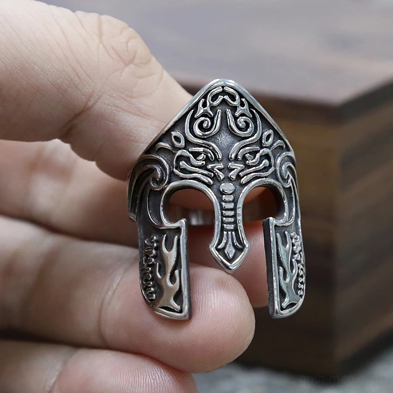 Nordic warrior helmet ring with flame-like carved guards, detailed front close-up on wooden background