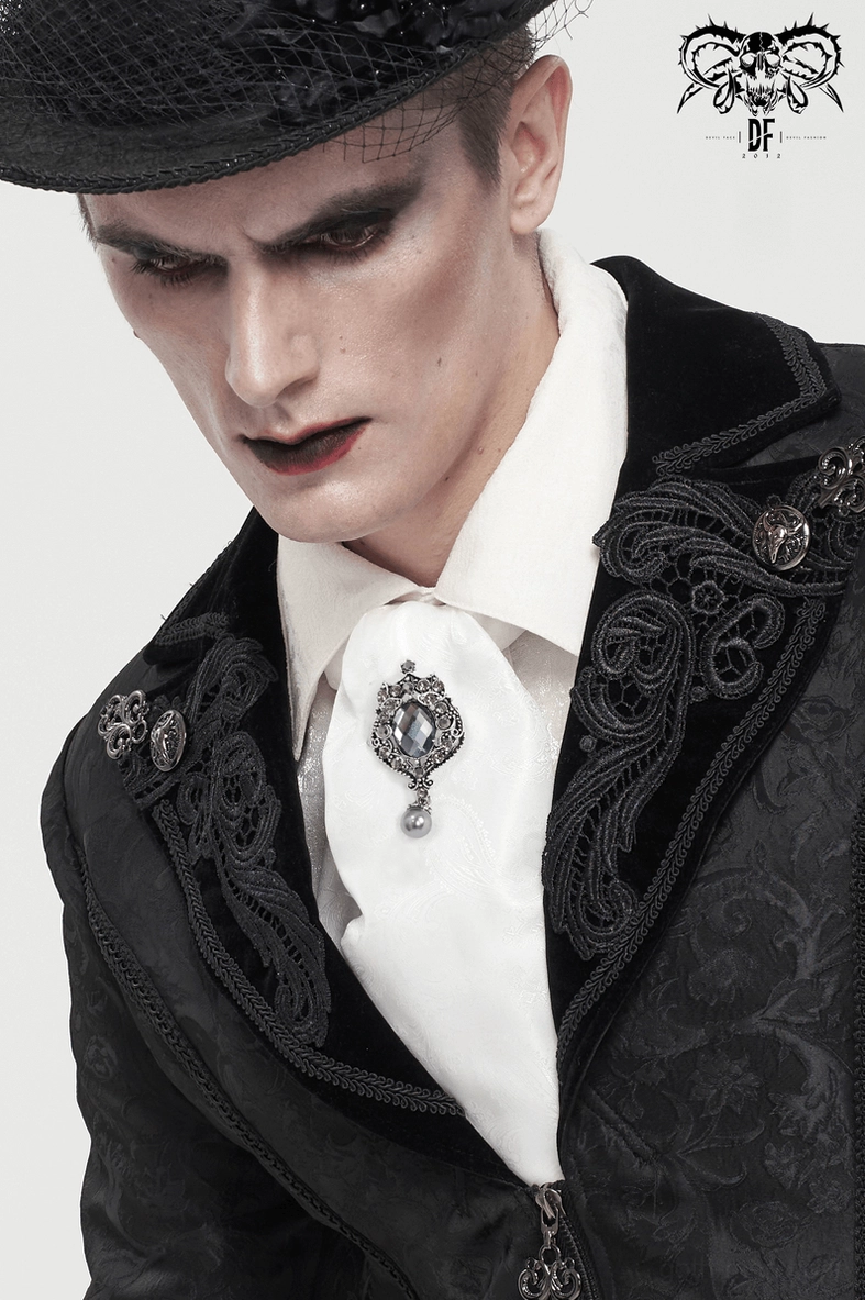Low angle close-up of white gothic ascot brooch with black embroidered suit jacket