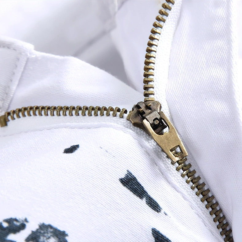 Detailed macro shot of antique brass zipper fly on white denim showing quality metal hardware and craftsmanship