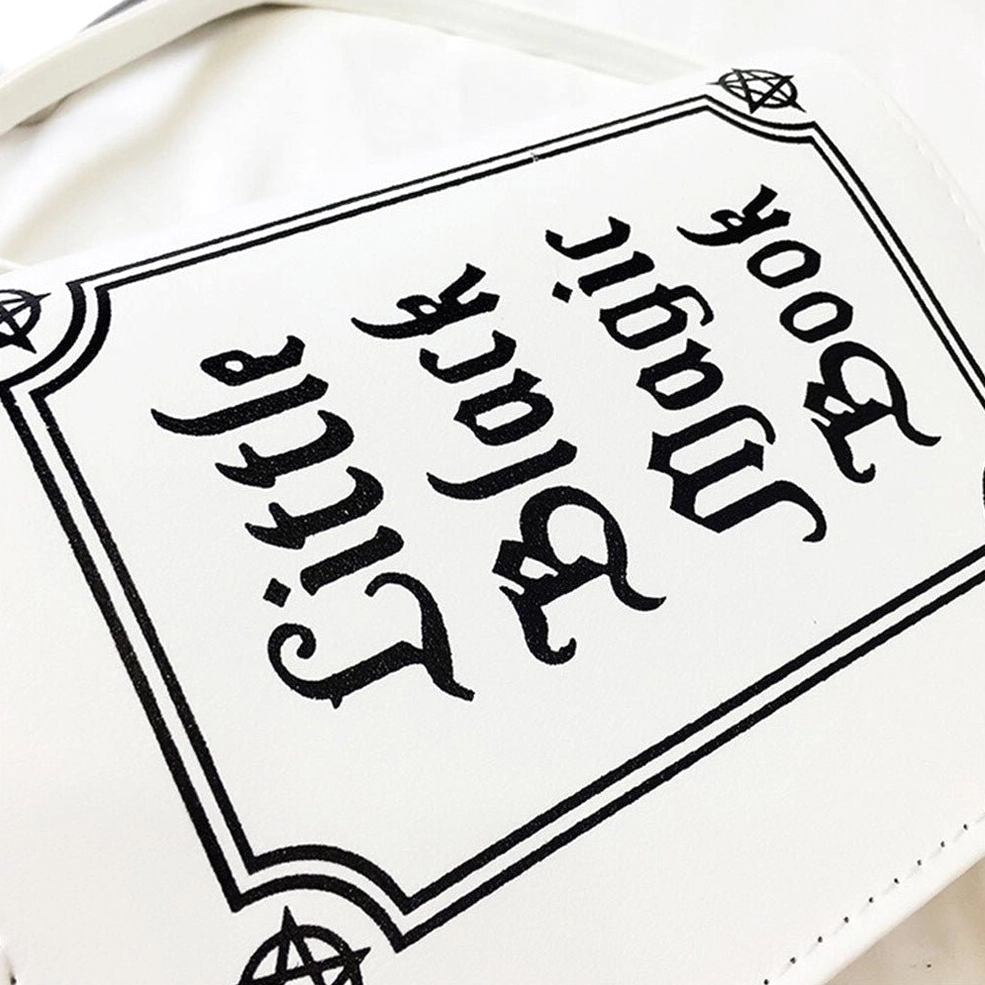 White gothic letter bag showing structured book-style construction and hasp closure mechanism