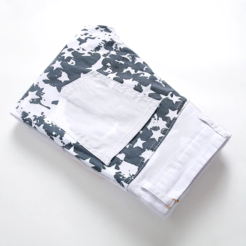 Top-down flat lay of folded white denim jeans displaying star pattern throughout fabric and back pocket details