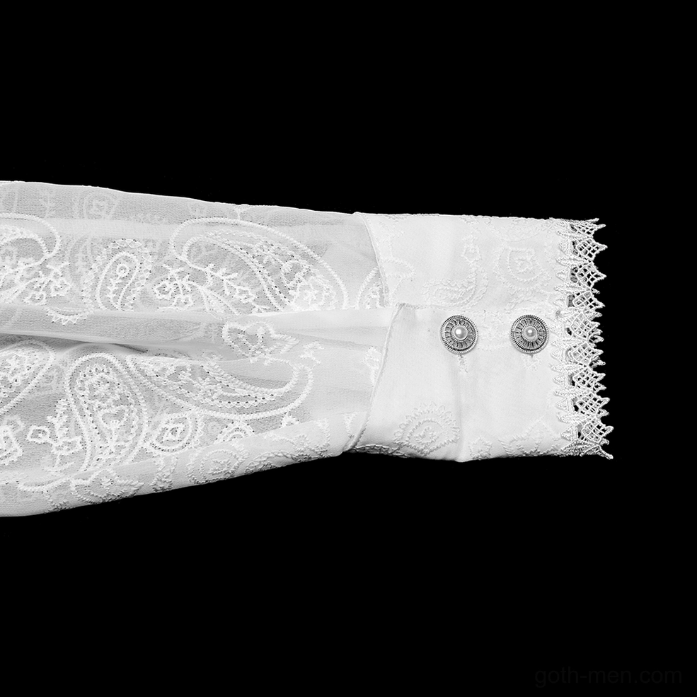 Close-up of white gothic shirt cuff design with lace trim, dual gem buttons, and embroidered sheer sleeve fabric
