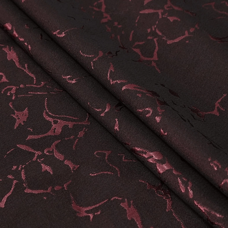 Wine red crackled jacquard fabric close-up showing gothic tailcoat pattern and weave