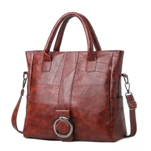 Wine red retro gothic leather tote with metal ring detail and adjustable crossbody strap - studio product shot