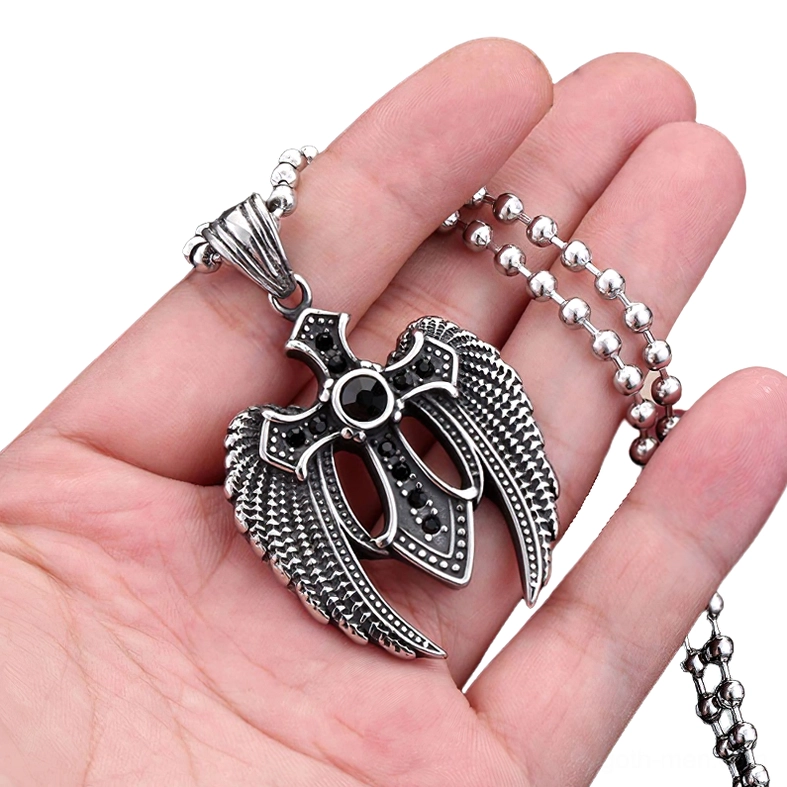 Winged cross gothic pendant held in hand showing scale and detail side view