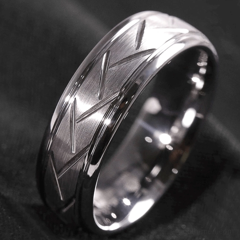 Two-tone metal chevron zigzag ring on dark fabric background, alternative fashion jewelry styling